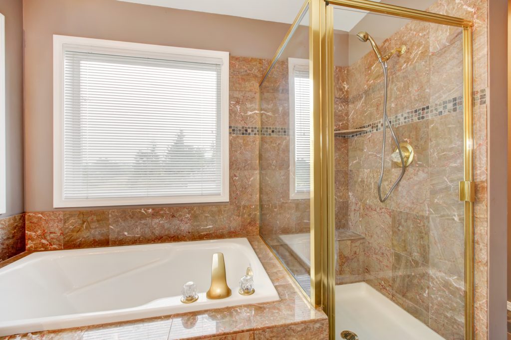 Luxury new granite shower and tub with gold metal.